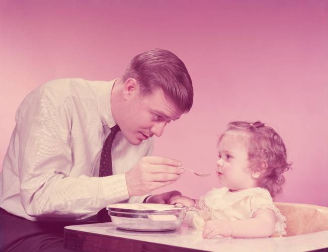 Édesapa eteti kisgyerekét (60-as évek, szépia)