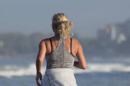 Női futó a vízparton