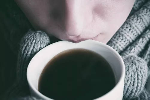 Kávét kortyoló nő