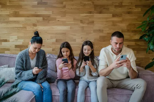 Négytagú család, mindegyik kezében okostelefon