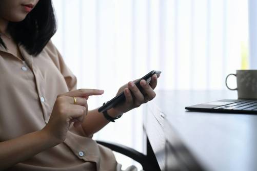 Mobiltelefonját használó nő