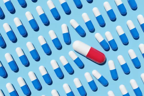 Kék-fehér kapszulák között egy nagyobb kék-piros