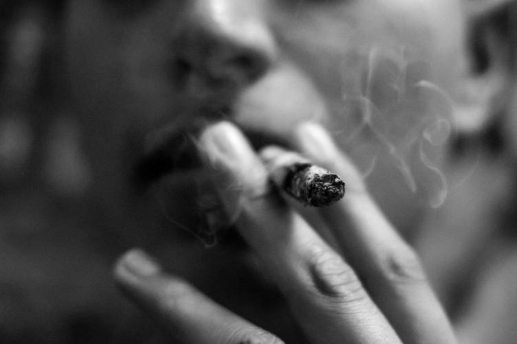 Kézben füstölő cigaretta