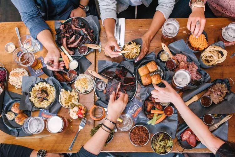 Terített asztal, válogató kezek