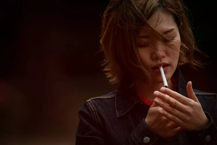 Cigarettára gyújtó nő