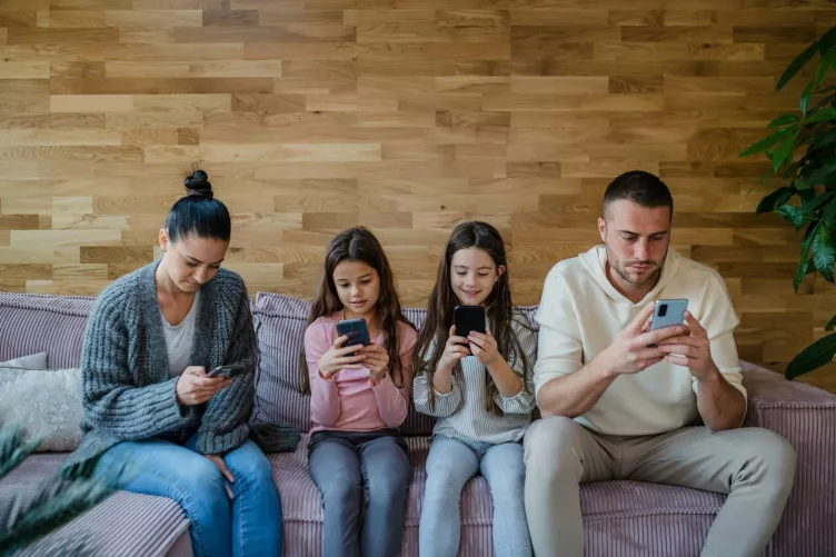 Négytagú család, mindegyik kezében okostelefon