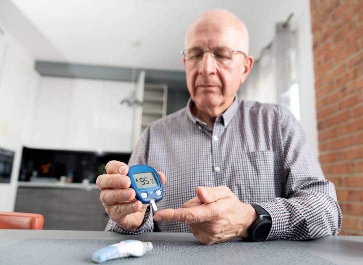 Vércukorszintjét mérő férfi